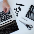 young woman cleaning her laptop key board 23 2149402391 young woman cleaning her laptop key board 23 2149402391